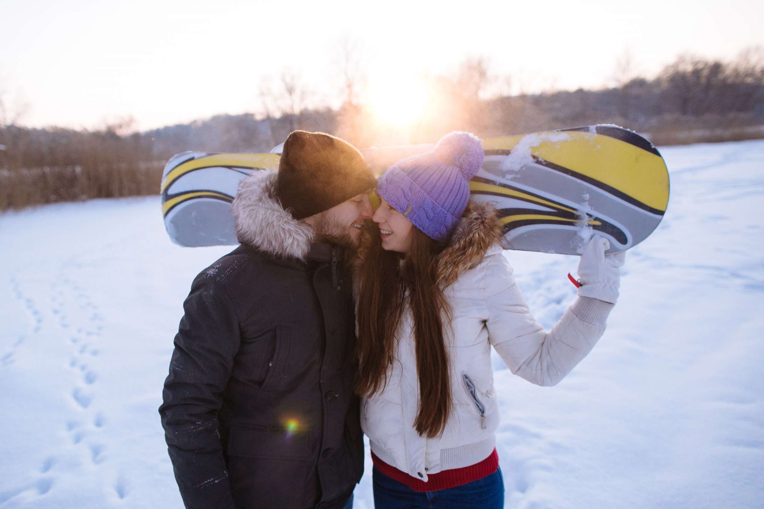 Beautiful couple in love of snowboarders in a frosty winter day. Close up portrait. Soft focus.
